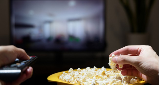 Bowl of popcorn with a TV screen in the background