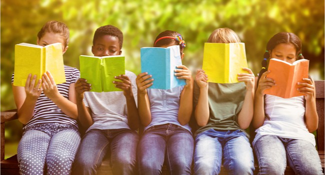 Five children sitting in a line reading books.