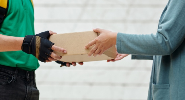 A delivery man handing a customer a parcel.