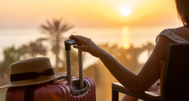 A woman sitting with a suitcase